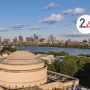 Aerial view of MIT dome with Charles River and Boston visible in the distance. Layered on top is a white circle with the number 24.