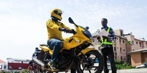 Person on yellow motorcycle talking to a man