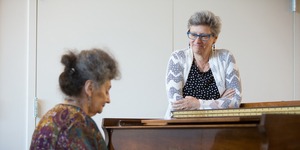 At 2Life Communities, Amy Schectman watches Tatyana Faynberg playing the piano