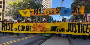 Protest banners: "Rise for Climate, Jobs, and Justice"