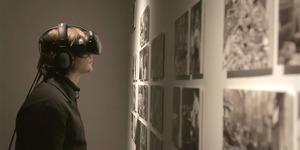 Man in VR glasses looking at a gallery wall 