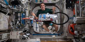 NASA astronaut and Expedition 63 Commander Chris Cassidy floats beside a bag of garbage in the International Space Station.