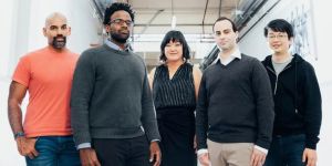 From left, Naveen Rao, Michael Carbin, Julie Shin Choi, Jonathan Frankle, and Hanlin Tang pose in a hallway.