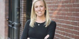 MIT alumna Kate Cincotta standing outside in front of a brick wall