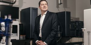 Sean Hunt stands in a room filled with lab equipment.