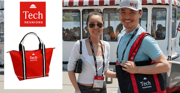 Image: two Tech Reunion attendees standing by the Charles River, holing a black and red tote bag with the Tech Reunions logo. Also, an overlay photo showing a red version of the bag. 