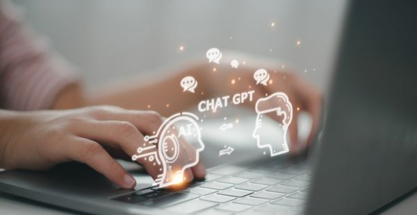 Photo illustration shows hands on a keyboard overlaid with a drawing of two heads, arrows, and the words "CHAT GPT."